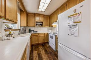 a kitchen with wooden cabinets and a white refrigerator at 838 Placer Avenue home in South Lake Tahoe +15 photos
