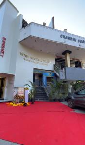 a building with a red carpet in front of it at Hotel Welcome Palace in Surat