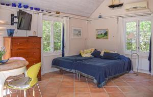 a bedroom with a bed and a table and chairs at Stunning Home In Borrby in Borrby +5 photos