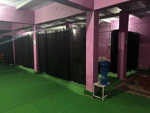 a room with a green floor and pink walls at Brijwasi Seva Sadan in Mathura +1 photo