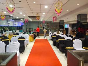a corridor with chairs and a red carpet in a restaurant at Hotel Welcome Palace in Surat
