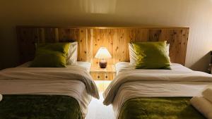 a bedroom with two beds with green pillows at Loving Garden Stayラビングガーデンステイ in Mima
