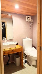 a bathroom with a sink and a toilet and a mirror at Loving Garden Stayラビングガーデンステイ in Mima