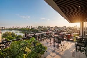 a balcony with chairs and a view of a river at Hoan Kiem Legend Ha Noi Hotel in Hanoi