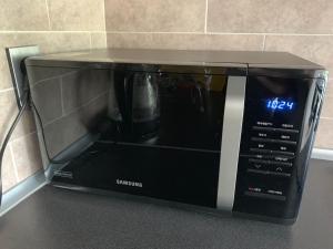 a black microwave sitting on top of a counter at Jeju Teracehill Pension in Jeju +8 photos