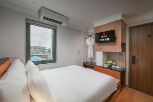 a white bedroom with a large bed and a window at Hoan Kiem Legend Ha Noi Hotel in Hanoi