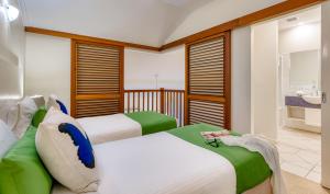 two beds in a room with a bathroom at Freestyle Resort Port Douglas in Port Douglas