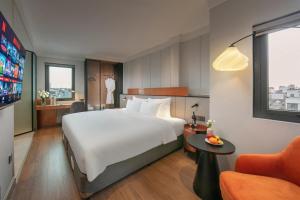 a hotel room with a large white bed and a couch at Hoan Kiem Legend Ha Noi Hotel in Hanoi +92 photos