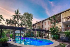 an outdoor swimming pool in front of a building at Freestyle Resort Port Douglas in Port Douglas