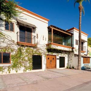 a white house with a palm tree in front of it at Paraiso Azul Hotel in Loreto
