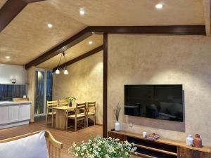 a living room with a large television on a wall at Stardome Apartment Dalat in Ấp Ða Lợi