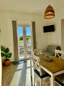 a living room with a table and chairs and a television at Villa Chimera in Pachino