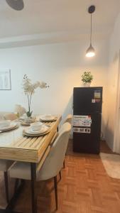 a dining room table with white chairs and a black refrigerator at Mellow Place Staycation in Naic