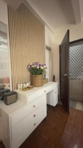 a white counter with a basket of flowers on it at Mellow Place Staycation in Naic