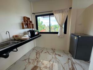 a small kitchen with a sink and a refrigerator at Leam Sai Seaview in Ban Laem Sai