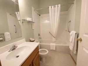 a bathroom with a sink and a toilet and a tub at NEWCASTLE COUNTRY INN in Drumheller