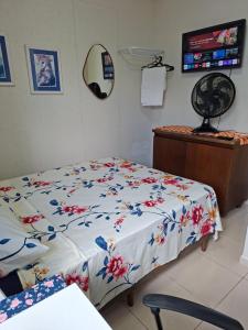 a bedroom with a bed with a floral comforter at Lar doce lar da Lu in Curitiba +42 photos