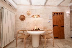 a room with a table and chairs and a door at Suite Amor in Alberobello