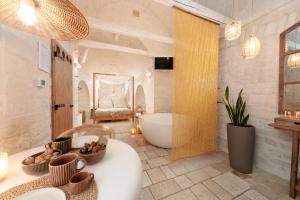 a bathroom with a large tub and a sink at Suite Amor in Alberobello +6 photos