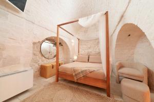 a bedroom with a canopy bed and a mirror at Suite Amor in Alberobello