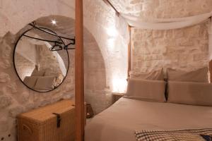 a bedroom with a bed and a mirror at Suite Amor in Alberobello