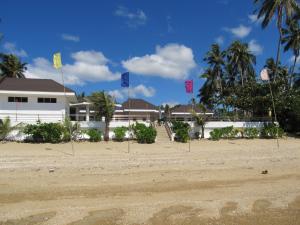 una casa en la playa con banderas delante en Ucoy Beach Resort, en Libertad