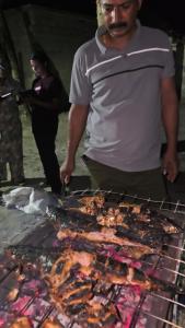 a man is cooking food on a grill at Blu Laguna Beach Homestay, Agatti Island, Lakshadweep - Only For Indian Nationals with valid entry permit in Agatti +15 photos