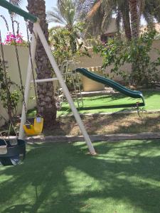 a swing set in a yard with a playground at Mooonlihgt in Ramlah