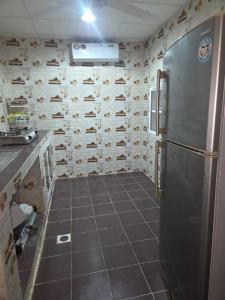 a kitchen with a refrigerator and a wall of shoes at Mooonlihgt in Ramlah