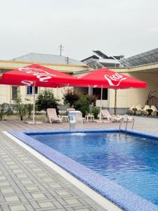a swimming pool with umbrellas and chairs and a pool at Shergiron PLAZA in Bukhara