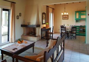 a living room with a table and a fireplace at Nymfes Villas in Porto Heli