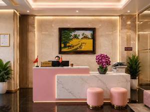 a lobby with a reception desk and pink stools at Pink Suite Saigon Airport Hotel in Ho Chi Minh City