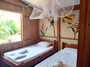 a small room with two beds and a window at Casa Almendros in Cabuya