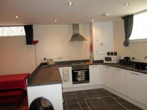 a kitchen with white cabinets and a stove top oven at The Goldings in Lewes