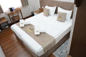 a bedroom with a large bed with white sheets and pillows at Shergiron PLAZA in Bukhara +31 photos