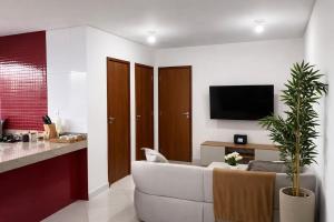 a living room with a white couch and a tv at Super Apt morada do Vale in Governador Valadares