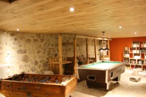 a room with a pool table in a room at La Maison de Jeanne, maison d'hôtes in Thiézac +50 photos