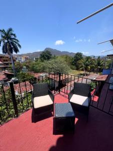 a balcony with two chairs and a view of the mountains at Casa Dreamy in Zihuatanejo