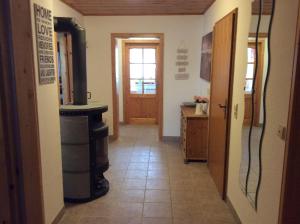 a hallway with a kitchen with a stove and a door at Ferienwohnung-Loesch in Neuenburg am Rhein +15 photos