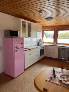 a kitchen with a pink refrigerator and a table at Ferienwohnung-Loesch in Neuenburg am Rhein