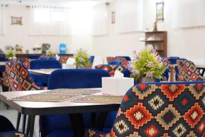 a room with tables and blue chairs with flowers on them at Shergiron PLAZA in Bukhara