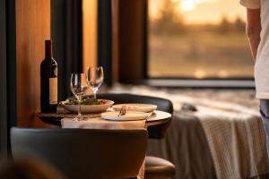 a table with a bottle of wine and wine glasses at AUTRA Resort Middleton in Middleton +13 photos
