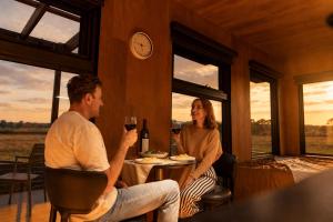 a man and woman sitting at a table with a glass of wine at AUTRA Resort Middleton in Middleton