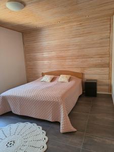 a bedroom with a bed with a wooden wall at Mökki Jyrkinkuja in Loimaa