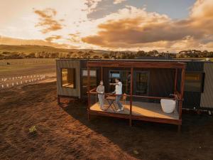 two people standing on the deck of a tiny house at AUTRA Resort Middleton in Middleton