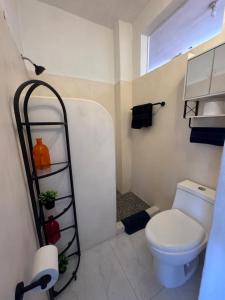 a bathroom with a white toilet and a shelf at Casa Dreamy in Zihuatanejo