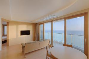 a living room with a table and a view of the ocean at Sol Beach Samcheok in Samcheok