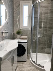 a bathroom with a shower and a washing machine at Pantanassa House in Nisaki +29 photos