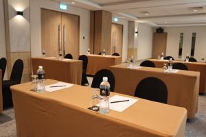 a conference room with brown tables and chairs at The Brunei Hotel in Bandar Seri Begawan