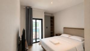a bedroom with a white bed and a window at SleepRest Azure Suites in Bagam